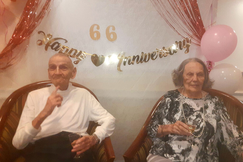 The Gardens at Castle Hills | Senior couple, David and Edna Grossett, posing with 66th anniversary decorations