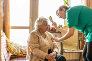 Gardens of Castle Hills | Caregiver assisting senior woman with combing her hair