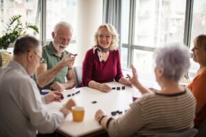 The Gardens of Castle Hills | Happy seniors around a table playing a game